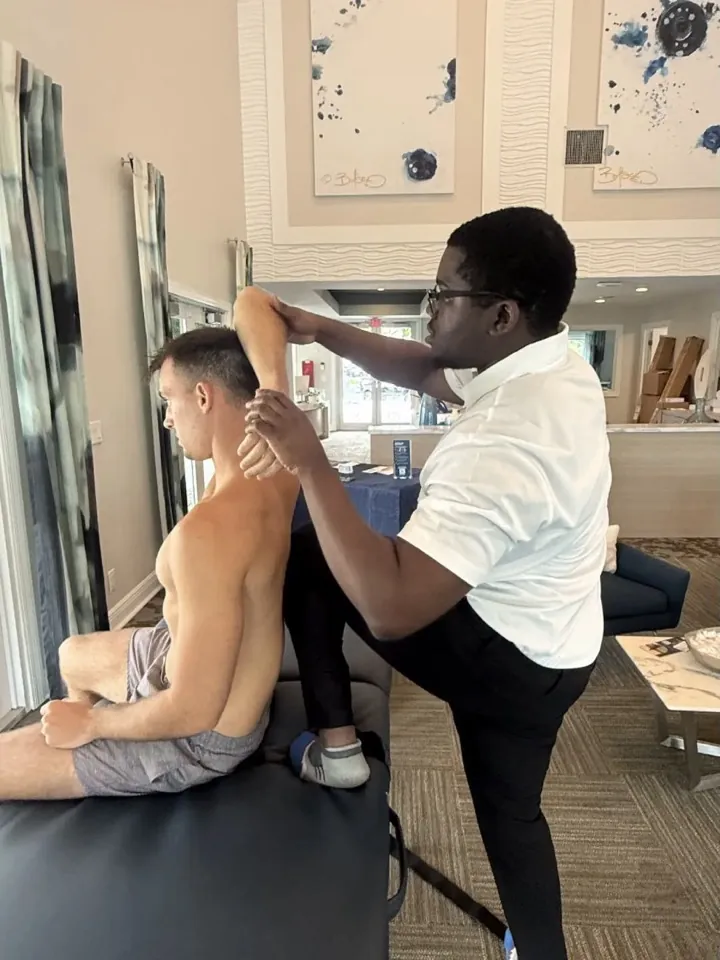A practitioner guiding a participant through an arm stretch