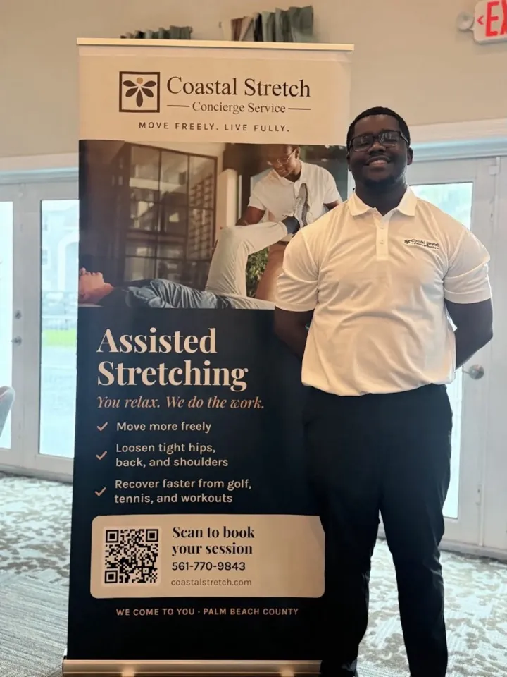 The practitioner beside the Coastal Stretch event banner